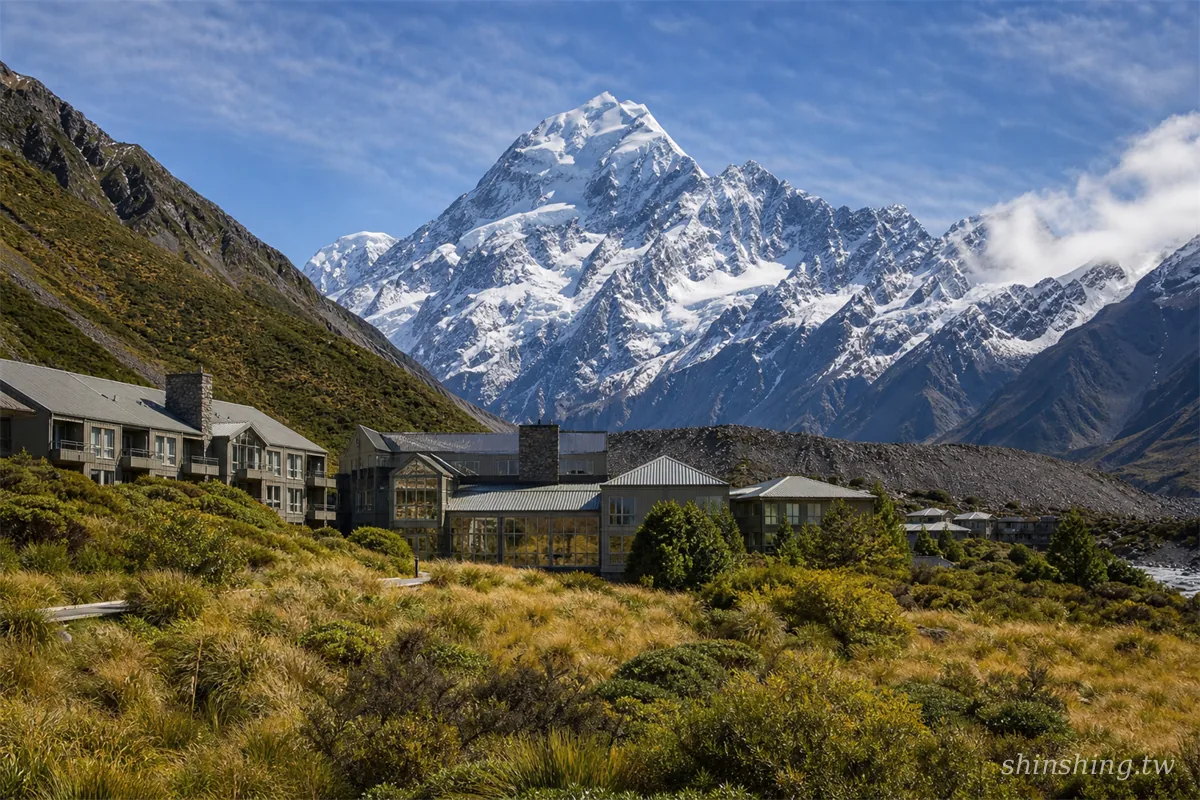 傍晚時分的 The Hermitage Hotel 正面，背後庫克山主峰垂直山牆清晰可見，Aoraki 村入口