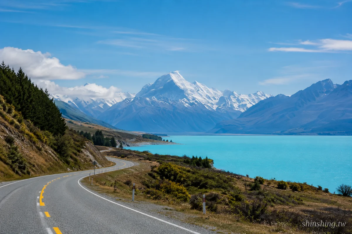 基督城到皇后鎮自駕公路，沿著 Lake Pukaki 牛奶藍湖畔通往庫克山雪峰，SH8 內陸路線最 iconic 景觀