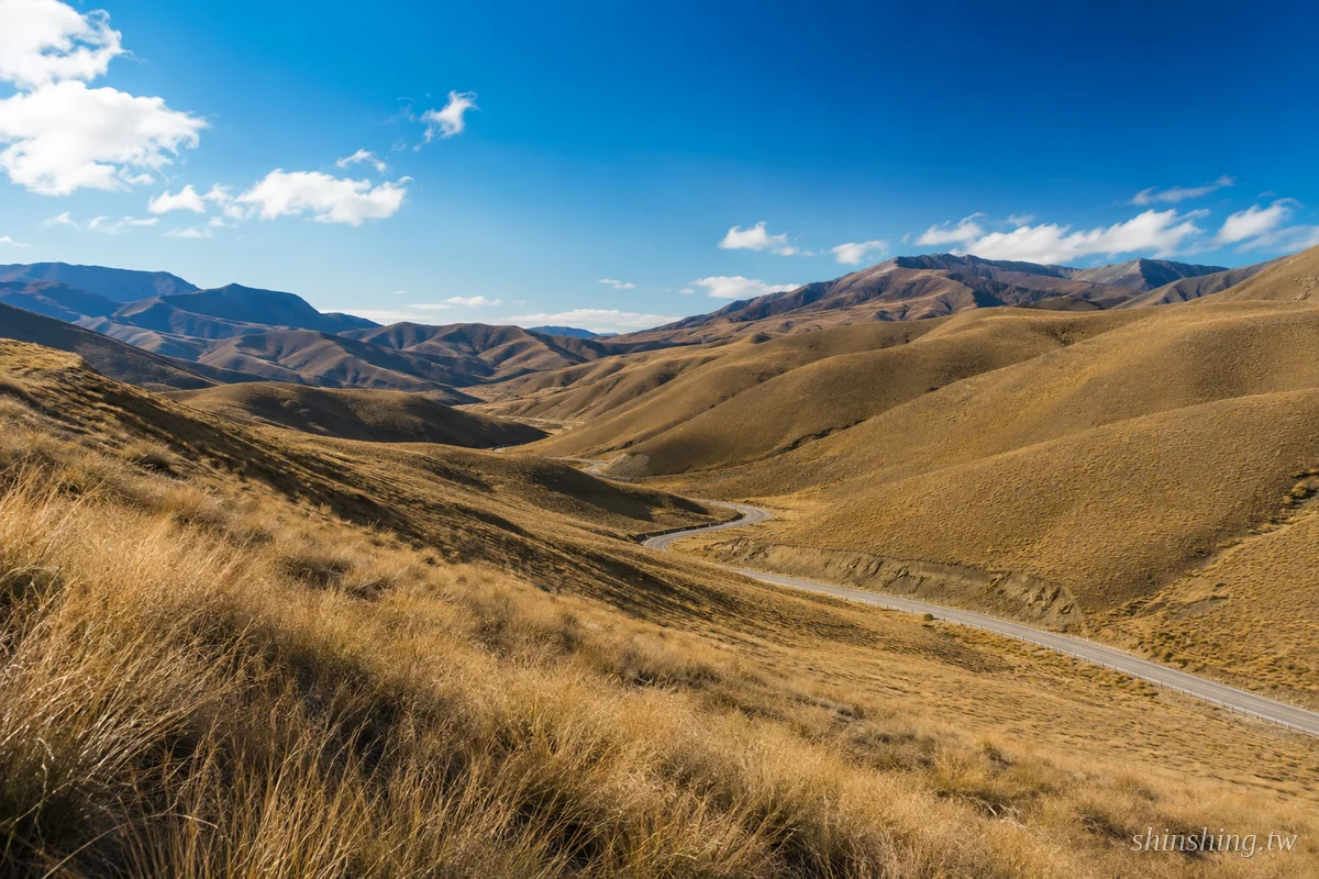 Lindis Pass 蜿蜒公路穿越金色草原丘陵