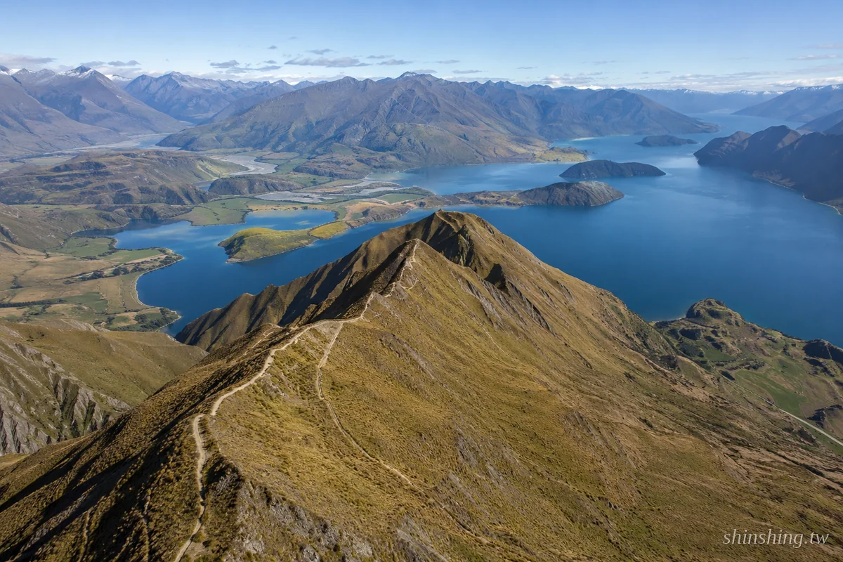Roy's Peak 山頂空拍 — 俯瞰瓦納卡湖、湖中島嶼與遠方南阿爾卑斯山脈